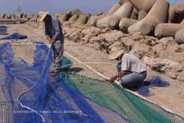 Image du Maroc Professionnelle de  Des ouvriers s'activent à réparer leurs filets de pêches au port de Laayoune, située à quelque kilomètre de la ville de Laayoune capitale du Sahara marocain, Vendredi 21 Septembre 2001. (Photo / Abdeljalil Bounhar) 